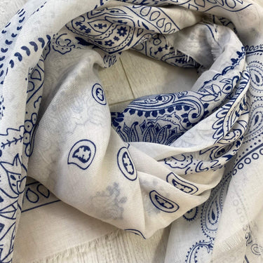White fabric with blue paisley patterns on a wooden surface