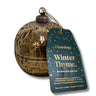 A textured metallic gold spherical candle container with a hanging dark teal tag that reads 'Osmology Winter Thyme' on a white background.