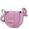 Pink leather saddle bag with a bow on a white background