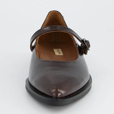 A dark brown leather Mary Jane shoe with a pointed toe and a decorative strap, shown from a front-three-quarter angle on a light gray background.