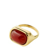 A gold signet ring featuring a smooth, polished red cabochon gemstone, set against a plain white background.