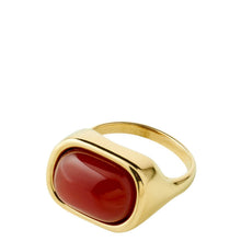 A gold signet ring featuring a smooth, polished red cabochon gemstone, set against a plain white background.