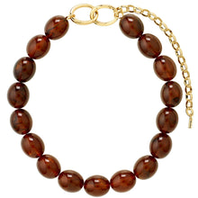 A beaded bracelet made of glossy, polished brown glass beads with a gold-tone clasp featuring interlocking oval links and an extender chain, shown on a plain white background.