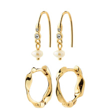 A set of gold-toned earrings on a plain white background, including two fishhook drop earrings with small clear stones and white pearl beads, and two abstract textured hoop earrings.