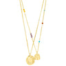 A gold layered necklace set featuring a long chain with a textured oval pendant, a shorter chain with a small hanging tag pendant, and delicate strands accented with colorful seed beads in yellow, purple, orange, turquoise, and white, shown against a plain white background.