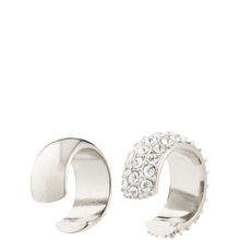 Two silver ear cuffs on a white background