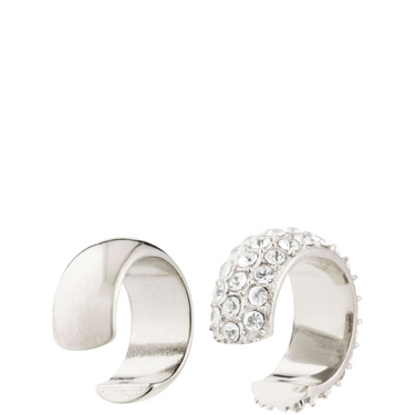 Two silver ear cuffs on a white background
