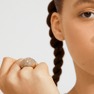 Close-up of a hand wearing a sparkling ring with a blurred background