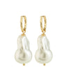Pearl earrings with gold hoops on a white background
