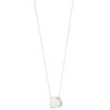 A delicate silver chain necklace with a polished, irregularly shaped disc pendant, shown against a solid white background.
