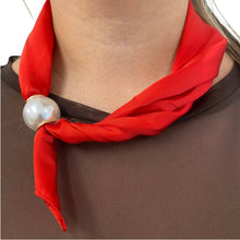 Red scarf with a pearl necklace draped over a brown garment