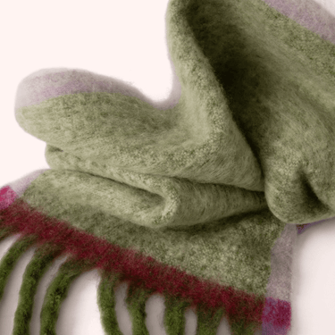 Close-up of green textured gloves with a red and white pattern on a white background