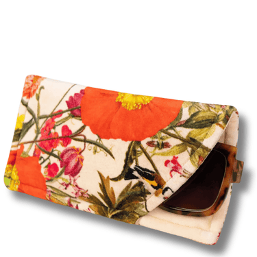 Floral patterned clutch with sunglasses on a white background