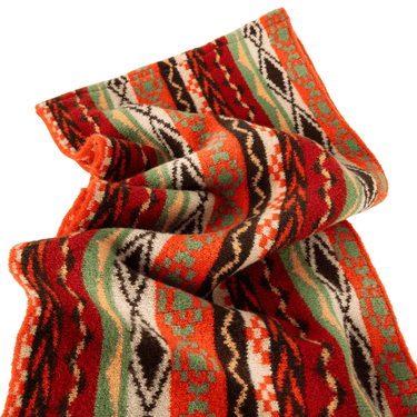 Colorful patterned fabric with red, green, and black colors on a white background