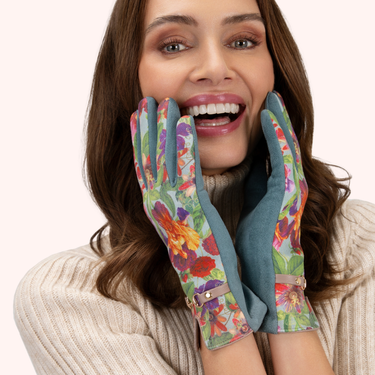 Woman wearing colorful floral gloves with a plain background
