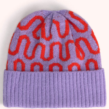 A knit beanie hat in lavender purple with a repeating red wavy pattern and a solid ribbed purple cuff, shown against a plain light background.