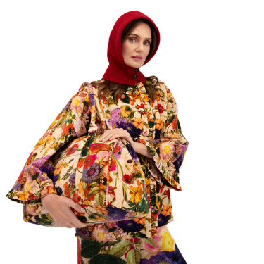 Woman wearing a colorful floral dress with a red hood on a white background