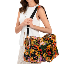 Woman holding a floral-patterned bag against a white background