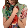 Woman wearing a floral patterned scarf with a colorful design.