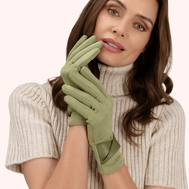 Woman wearing green gloves and a beige sweater on a white background