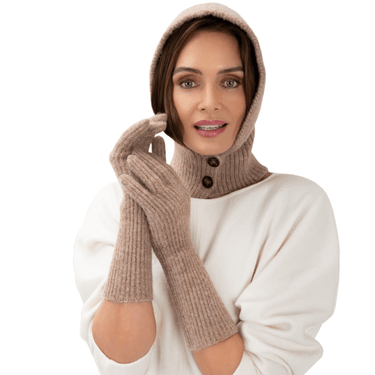 Woman wearing beige knitted gloves and a matching hood on a white background