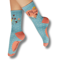 Blue socks with floral patterns and text on a white background