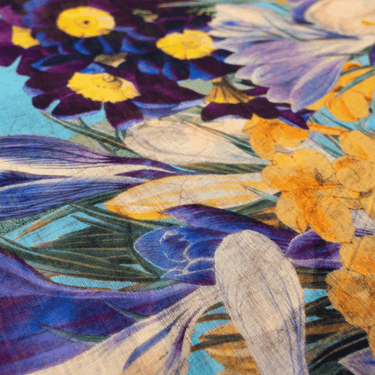 Close-up of a fabric with floral patterns in purple, yellow, and blue.