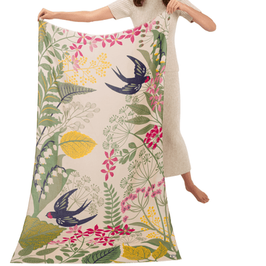 Person holding a floral and bird patterned fabric