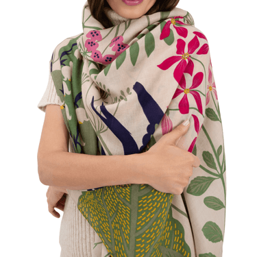 Person wearing a colorful floral and leaf patterned scarf on a white background