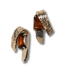 Gold hoop earrings with brown gemstones on a white background