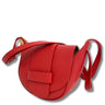 Red leather handbag with a strap on a white background