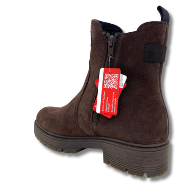 A dark brown suede ankle boot with a side zipper, a thick lug sole, and a red retail tag attached near the zipper, shown on a white background.