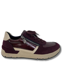 A low-top sneaker by Riddler, featuring a mix of burgundy patent leather and burgundy suede panels, beige side stripes, a beige heel tab, and a silver zipper on the side.