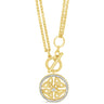 A gold pendant necklace featuring a circular Celtic knot design with a small clear center stone and a halo of tiny clear stones, suspended from a delicate gold chain on a white background.
