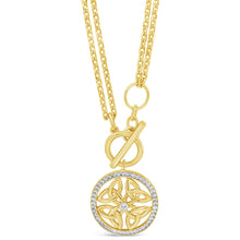 A gold pendant necklace featuring a circular Celtic knot design with a small clear center stone and a halo of tiny clear stones, suspended from a delicate gold chain on a white background.