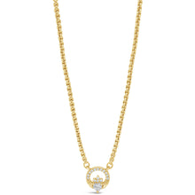 A delicate gold chain necklace featuring a double-ring pendant with a central clear gemstone, displayed against a solid white background.