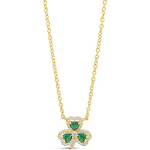 A gold chain necklace with a shamrock pendant featuring three green heart-shaped stones and small clear accent stones, shown on a plain white background.