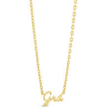 A delicate yellow gold chain necklace featuring a cursive script pendant that reads 'Grá', shown against a solid white background.