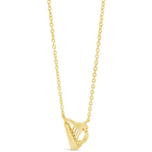 A delicate gold chain necklace featuring a small, stylized harp pendant, shown against a solid white background.