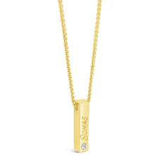 A gold bar necklace with a rectangular pendant engraved with the name 'SOMAS' and a small clear gemstone, shown on a white background.