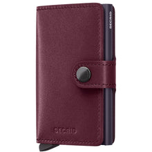 A Secrid Miniwallet in burgundy leather with a dark navy blue pen slot and snap closure, shown on a plain white background.