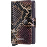 A Secrid Miniwallet in a snakeskin pattern featuring shades of brown, black, and purple, with a dark metallic snap button and side clip, shown on a plain white background.