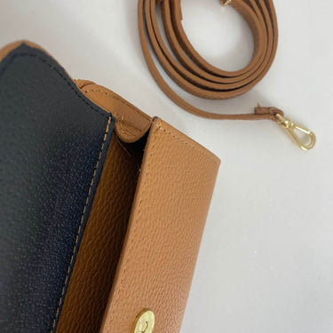 Close-up of a brown leather bag with a gold clasp on a white background