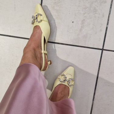 Person wearing light pink pants and yellow shoes on a tiled floor