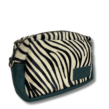 Zebra patterned pouch with green leather trim on a white background