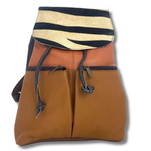 A color-blocked leather shoulder bag with a tan front pocket, a rust-orange middle section, and a flap top featuring black and cream zebra-like stripes. The bag has dark gray drawstrings and is photographed on a white background with a soft drop shadow.