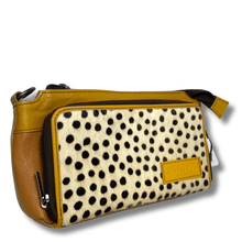 Handbag with polka dot pattern and brown leather accents on a white background