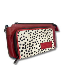 A rectangular crossbody bag featuring a red leather exterior and a front pocket with a black and white dalmatian print. A red leather brand patch on the front pocket displays the name 'SCALPERS'.