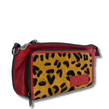 A red leather crossbody bag with a large front pocket featuring a yellow and black leopard print pattern, shown on a white background.