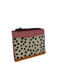 A small card holder or wallet with a pink leather top, a beige cowhide panel with black spots, and red leather trim, shown on a plain white background.